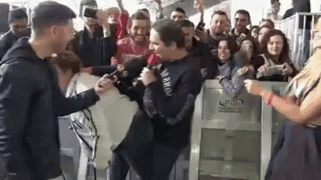 Man Holding Microphone In Crowd GIF