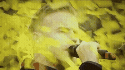 Man Holding Microphone In Field Of Yellow Papers GIF