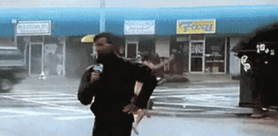 Man Holding Microphone In Front Of Store GIF