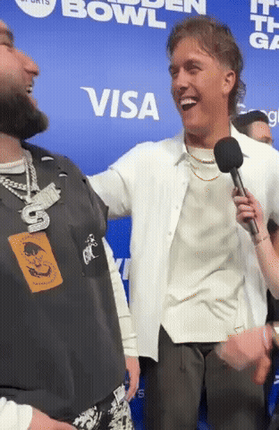 Man Holding Microphone Laughs In Front Of Visa Sign GIF