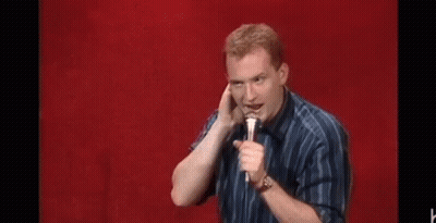 Man Holding Microphone Making Funny Face Red Background GIF