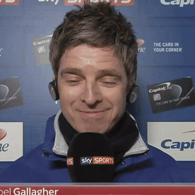Man Holding Microphone Next To Two Men GIF