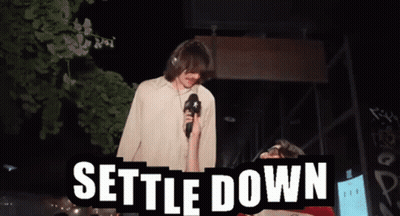 Man Holding Microphone Says Settle Down GIF
