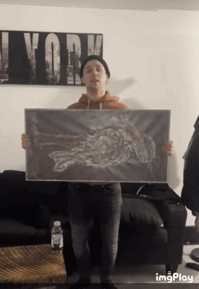 Man Holding Painting With Work On Wall GIF