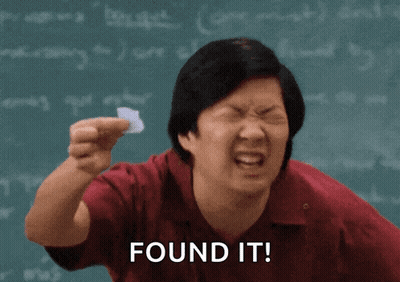 Man Holding Paper In Front Of Chalkboard Saying Found It GIF