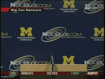 Man Holding Paper In Front Of M Logo GIF