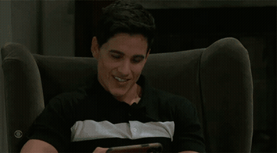 Man Holding Phone With Two Men Kissing On Screen GIF