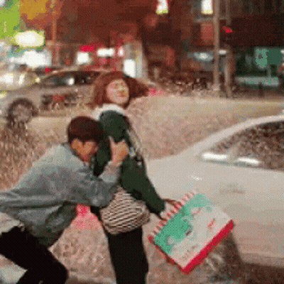 Man Holding Pizza Box Pushing Woman In Rain GIF