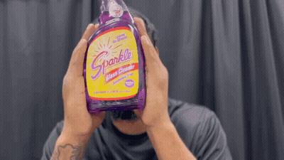 Man Holding Purple Sparkle Glass Cleaner GIF