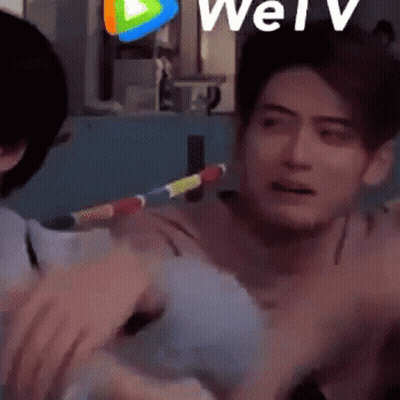 Man Holding Rainbow Hula Hoop While Another Man Watches GIF