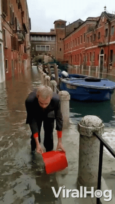 Man Holding Red Bucket In Flood GIF