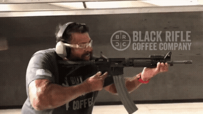Man Holding Rifle in Front of Black Rifle Coffee Company Logo