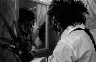 Man Holding Scissors In Front Of Mirror GIF