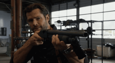 Man Holding Shotgun in Garage