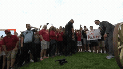 Man Holding Sign Saying Colones Are Purry GIF