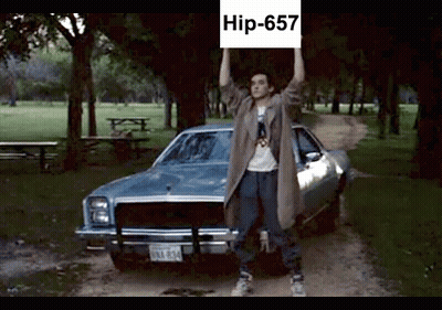 Man Holding Sign Saying Hip-657 In Front Of Car GIF