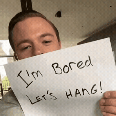 Man Holding Sign Saying I'm Bored Let's Hang GIF
