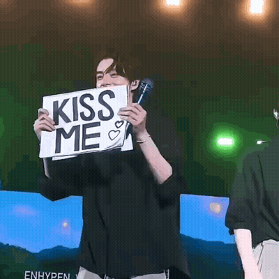 Man Holding Sign Saying Kiss Me With Microphone GIF