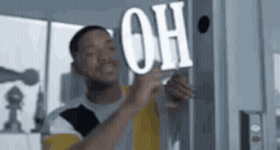 Man Holding Sign Saying Oh On Wall GIF