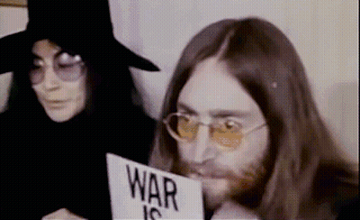 Man Holding Sign Saying War Is Next To Woman GIF