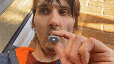 Man Holding Small Object With Light In Mouth GIF