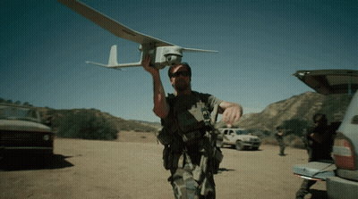 Man Holding Small Plane With Letter L GIF