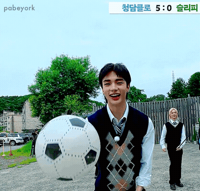 Man Holding Soccer Ball In Front Of Pabeyork Sign GIF