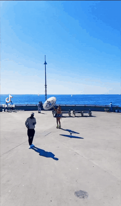 Man Holding Sombrero And Woman Rollerblading GIF
