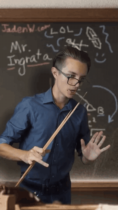 Man Holding Stick In Front Of Blackboard With Mr. Ingrata GIF