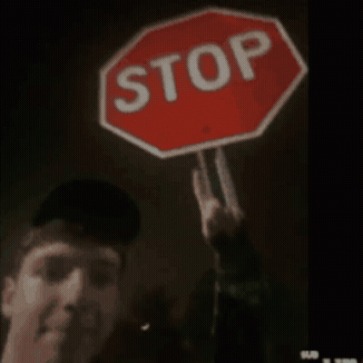 Man Holding Stop Sign Making Peace Sign GIF