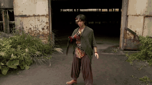 Man Holding Sword Near Rusty Building GIF