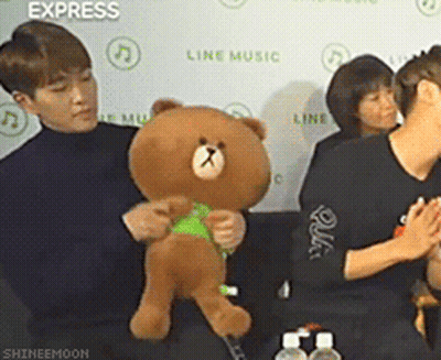 Man Holding Teddy Bear In Front Of Express Wall GIF
