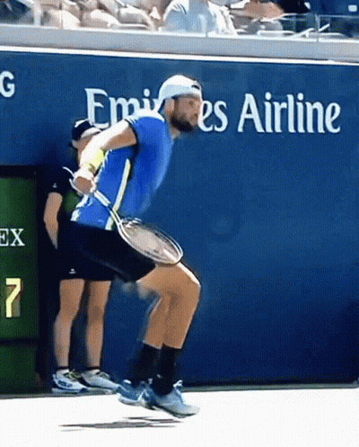 Man Holding Tennis Racket In Front Of Emirates Sign GIF