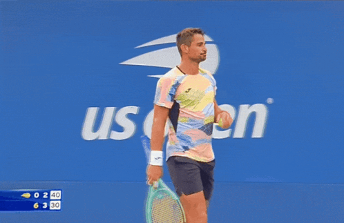 Man Holding Tennis Racket In Front Of J.P. Morgan Sign GIF