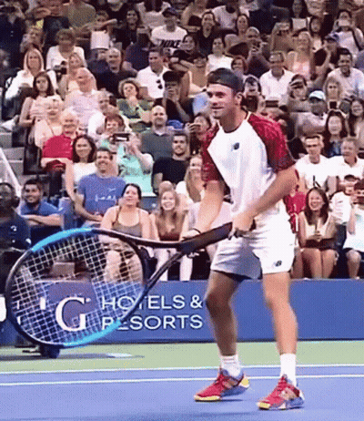 Man Holding Tennis Racquet In Front Of G Hotels & Resorts Sign GIF
