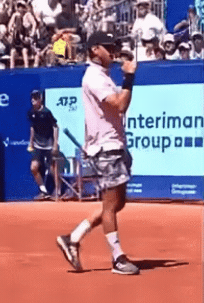Man Holding Tennis Racquet In Front Of Interman Group Banner GIF