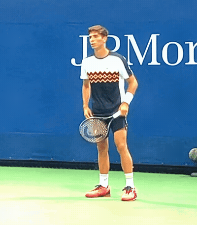 Man Holding Tennis Racquet In Front Of JPMorgan Sign GIF