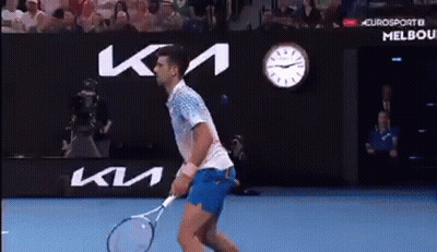 Man Holding Tennis Racquet In Front Of KM Sign GIF