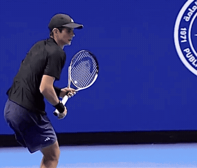Man Holding Tennis Racquet In Front Of L'A Sign GIF