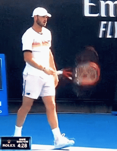 Man Holding Tennis Racquet In Front Of Rolex 4:28 Sign GIF
