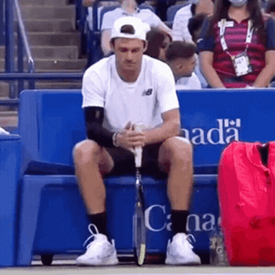 Man Holding Tennis Racquet In Front Of Rolex Sign 4:28 GIF