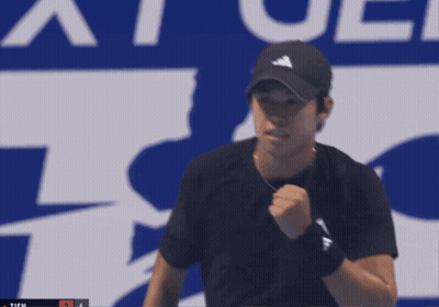 Man Holding Tennis Racquet In Front Of Ticu Sign GIF