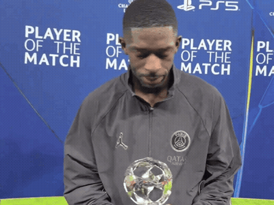Man Holding Trophy In Front Of Player Of The Match Sign GIF