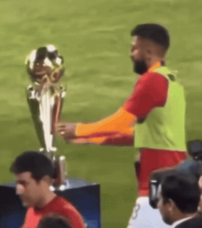 Man Holding Trophy On Soccer Field GIF