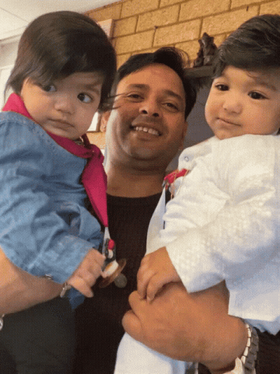 Man Holding Two Babies And Smiling GIF