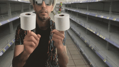 Man Holding Two Rolls Of Toilet Paper In Empty Store GIF