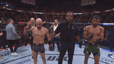 Hombre sosteniendo cinturón de UFC en ring GIF