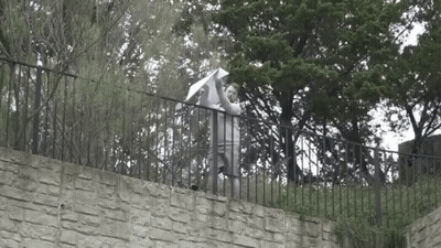 Man Holding Umbrella On Stone Wall GIF