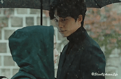 Man Holding Umbrella Over Woman In Rain GIF