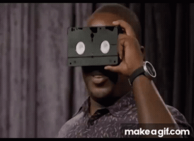 Man Holding VHS Tape Over Face GIF